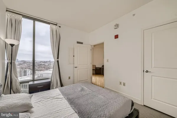 a bedroom with a bed and a large window