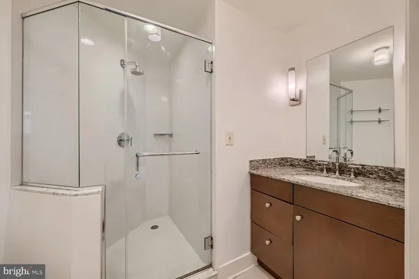 a bathroom with a granite countertop sink mirror and shower