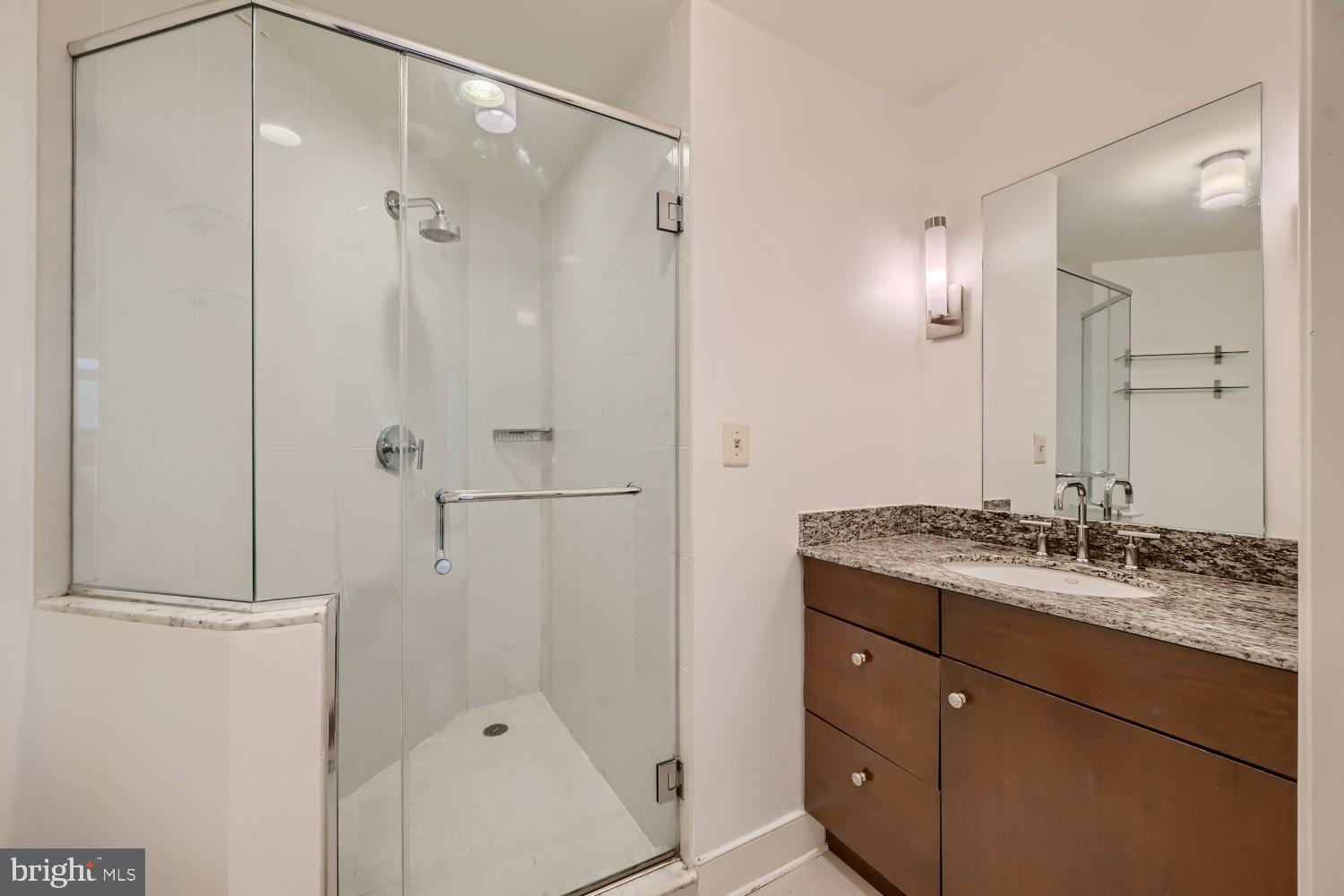 675 President Street, Unit 2107 Baltimore, MD 21202 - Photo 19 of 39 a bathroom with a granite countertop sink mirror and shower