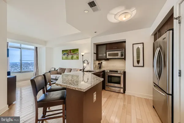 a kitchen with stainless steel appliances granite countertop a refrigerator stove microwave and sink