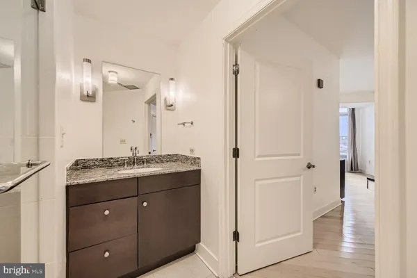 a bathroom with a granite countertop sink a mirror and a shower