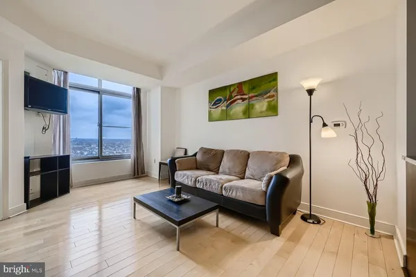 a living room with furniture a flat screen tv and a floor to ceiling window