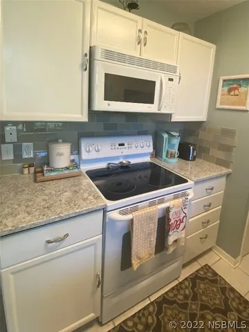 a kitchen with stainless steel appliances granite countertop a stove and a microwave