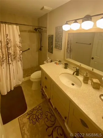 a bathroom with a sink and mirror with toilet