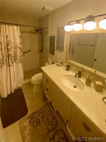 a bathroom with a sink and mirror with toilet