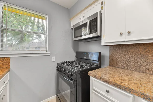 a kitchen with stainless steel appliances granite countertop a sink stove and microwave