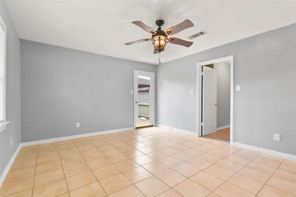 a view of an empty room and chandelier fan