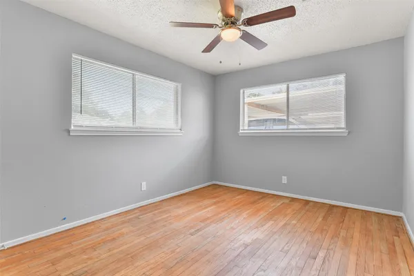 a view of room with window ceiling fan and wooden floor