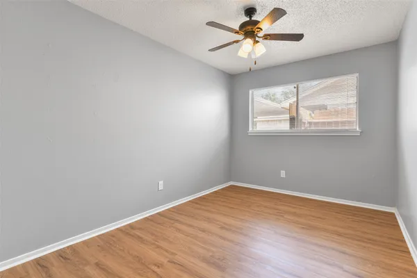a view of a room with wooden floor and a ceiling fan