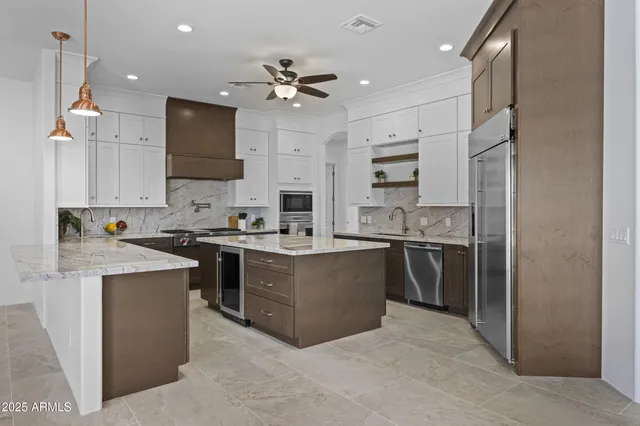 a kitchen with stainless steel appliances kitchen island a sink stove and refrigerator
