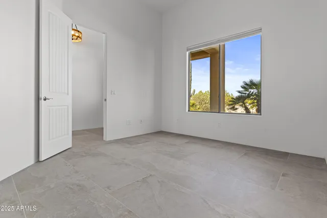 a spacious bedroom with a bed and a painting on the wall