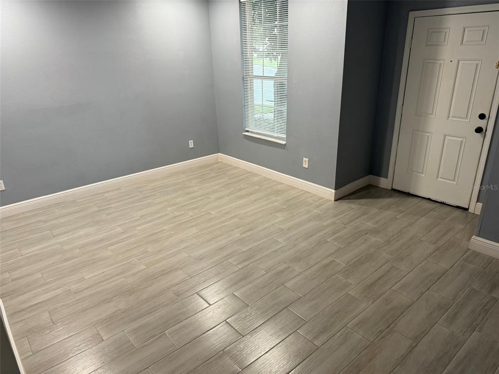 1325 Lyonshire Drive Wesley Chapel, FL 33543 - Photo 17 of 20 an empty room with wooden floor and windows