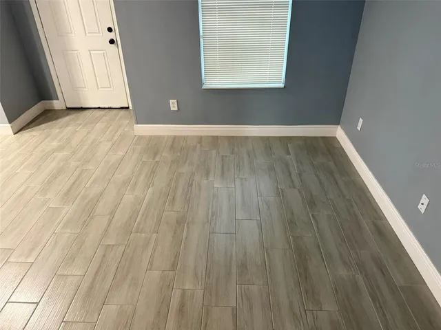 wooden floor in an empty room with a window
