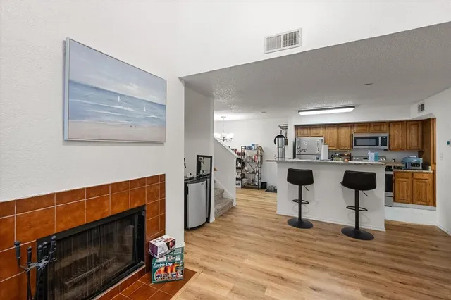 a living room with furniture a kitchen and a fireplace