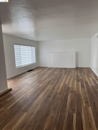 a view of an empty room and wooden floor