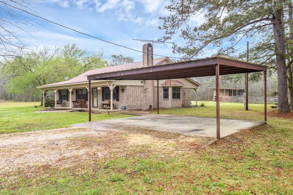 a view of house with a backyard