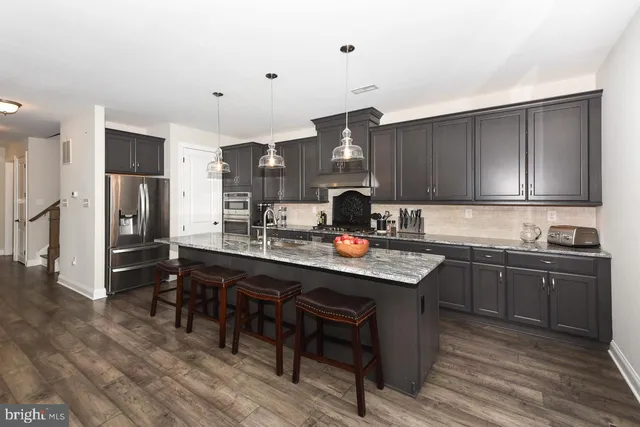 a kitchen with a sink a stove and chairs