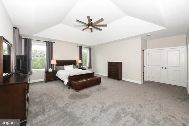 a spacious bedroom with a bed and a chandelier