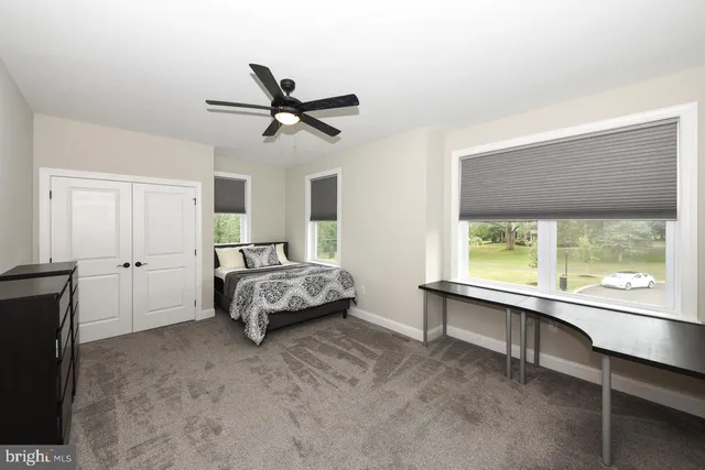 a bedroom with a bed and a large window