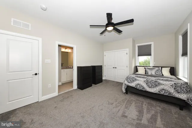 a bedroom with a bed and a ceiling fan