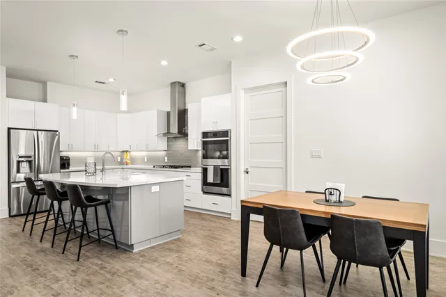 a kitchen with kitchen island a dining table and chairs