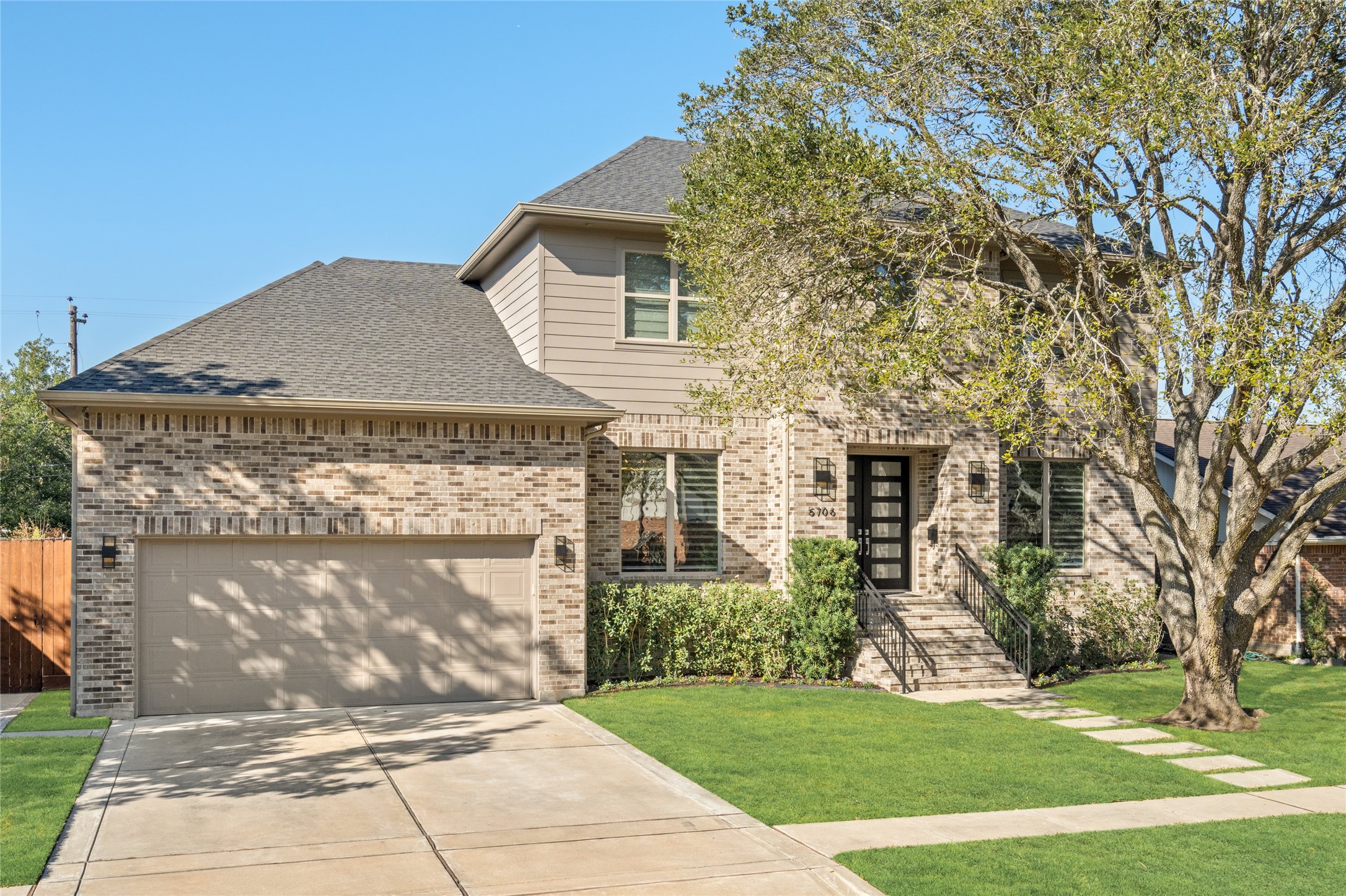 5706 Birdwood Road Houston, TX 77096 - Photo 2 of 50 This contemporary two-story brick home has a double wide spacious driveway leading to a tandem 3-car garage. The house features a well-maintained lawn, designer concrete sidewalk, a mature shade tree in the front yard, and a welcoming entrance with steps and manicured landscapiing.