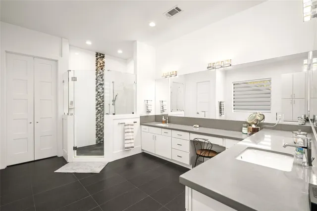 a large bathroom with a double vanity sink a mirror and a bathtub
