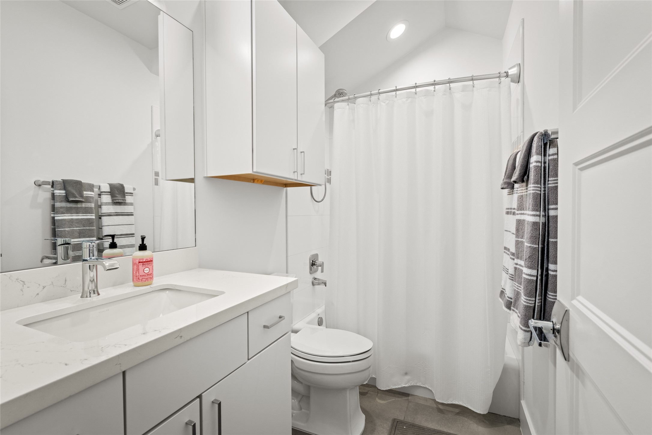 5706 Birdwood Road Houston, TX 77096 - Photo 31 of 50 West bathroom with quartz counter top and white cabinetry with accent tile in the shower bath. Tile floor and bright with designer fixtures and neutral tones.