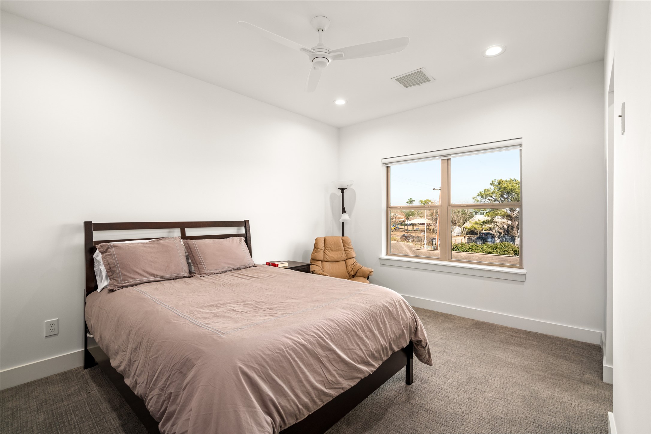 5706 Birdwood Road Houston, TX 77096 - Photo 35 of 50 The third bedroom is bright and spacious, featuring a large window with another pleasant view. It includes a modern ceiling fan, neutral-toned walls, and carpeted flooring, ceiling fan and recessed lighting. Custom shade on the window.