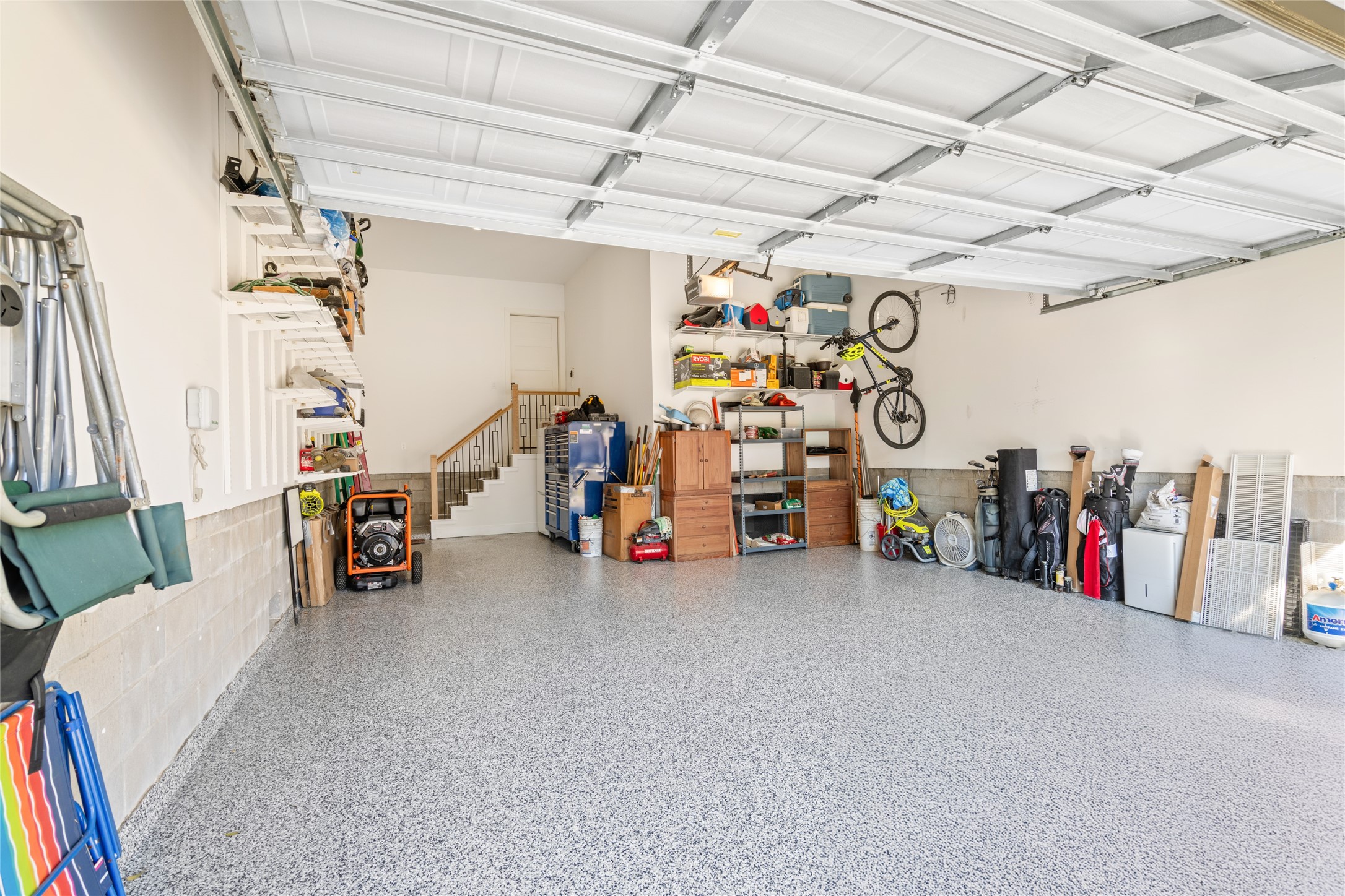 5706 Birdwood Road Houston, TX 77096 - Photo 38 of 50 Meticulous 3-car garage with room for more! Per the owner, the slab is designed for car lifts. Oversized for extra storage and easy access to the interior staircase that leads into the utility room. Storage shelving, well lit and so clean! The floor has a shiny new epoxy coating.
