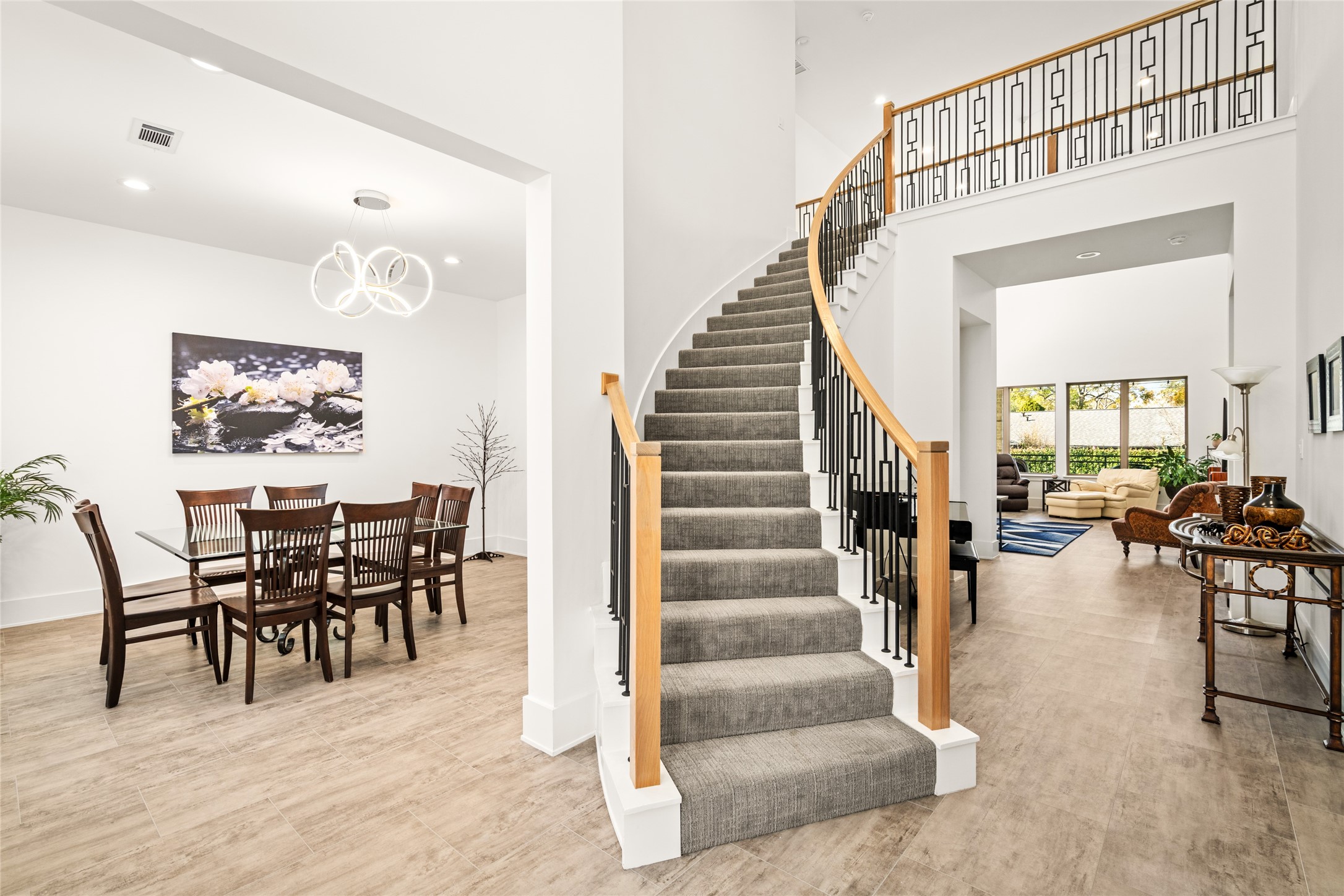 5706 Birdwood Road Houston, TX 77096 - Photo 4 of 50 Experience the ope concept layout upon entering this home. A beautiful architectural feature is the curved staircase with wrought iron and wood railing, the dining room is to the left and a view to the family room is just past the entry hall.