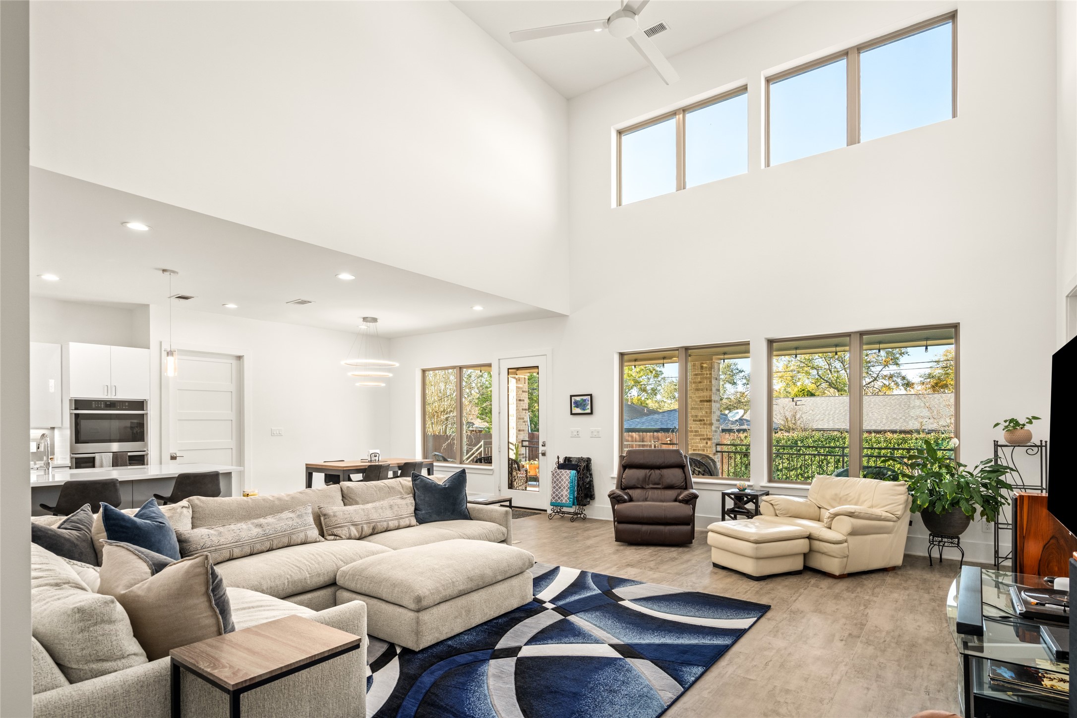 5706 Birdwood Road Houston, TX 77096 - Photo 49 of 50 This spacious family room features high ceilings and large windows, offering plenty of natural light and spectacular vies of the back patio and yard. The open floor plan seamlessly connects to the kitchen, creating an inviting space perfect for entertaining. Modern finishes and neutral tones enhance the room's contemporary feel.