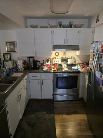 a kitchen with stainless steel appliances a stove a sink and white cabinets