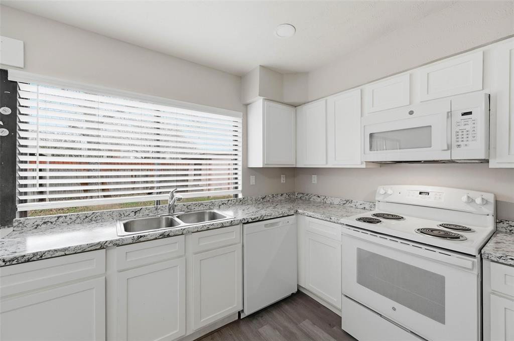 2102 Lewis Trail Grand Prairie, TX 75052 - Photo 11 of 33 a kitchen with granite countertop white cabinets and white appliances