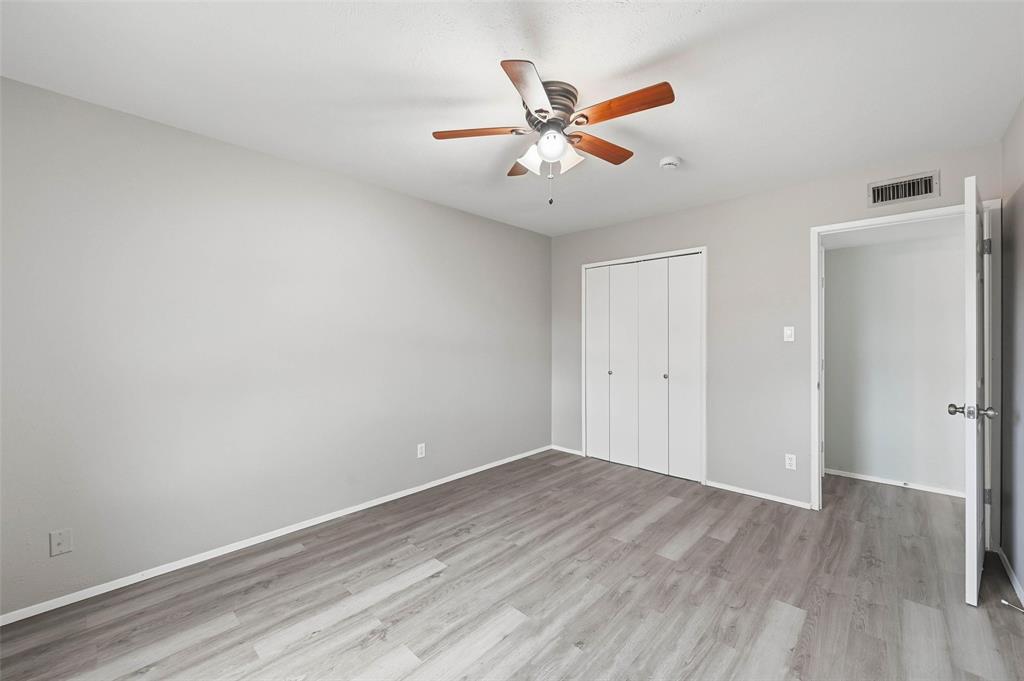 2102 Lewis Trail Grand Prairie, TX 75052 - Photo 20 of 33 an empty room with wooden floor closet and fan