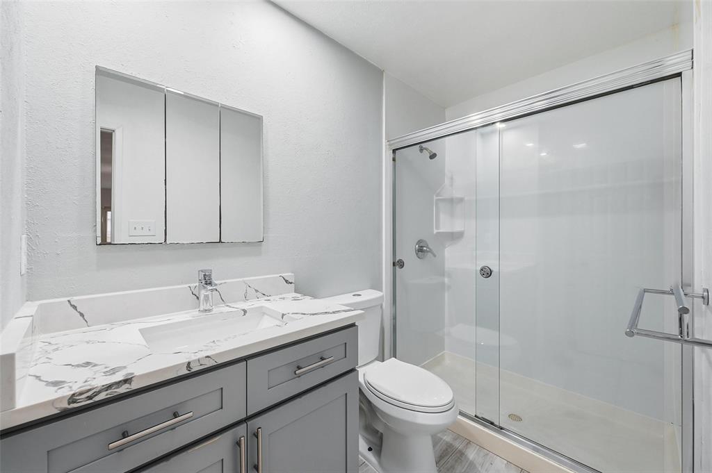 2102 Lewis Trail Grand Prairie, TX 75052 - Photo 24 of 33 a bathroom with a granite countertop sink a toilet and shower