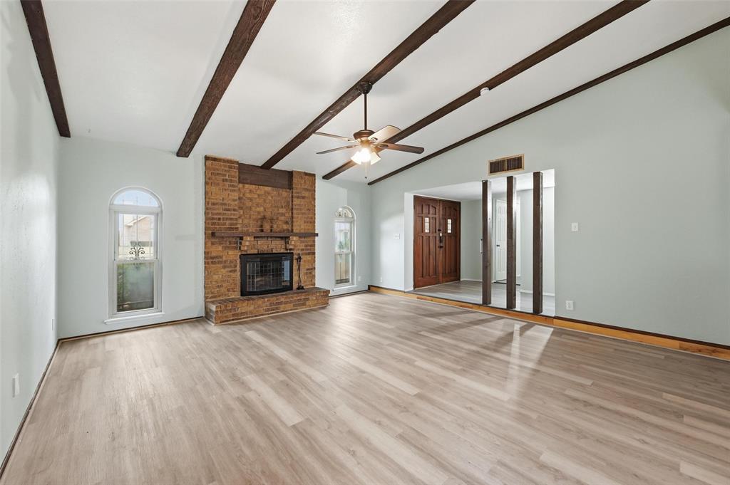 2102 Lewis Trail Grand Prairie, TX 75052 - Photo 4 of 33 a view of an empty room with wooden floor fireplace and a window