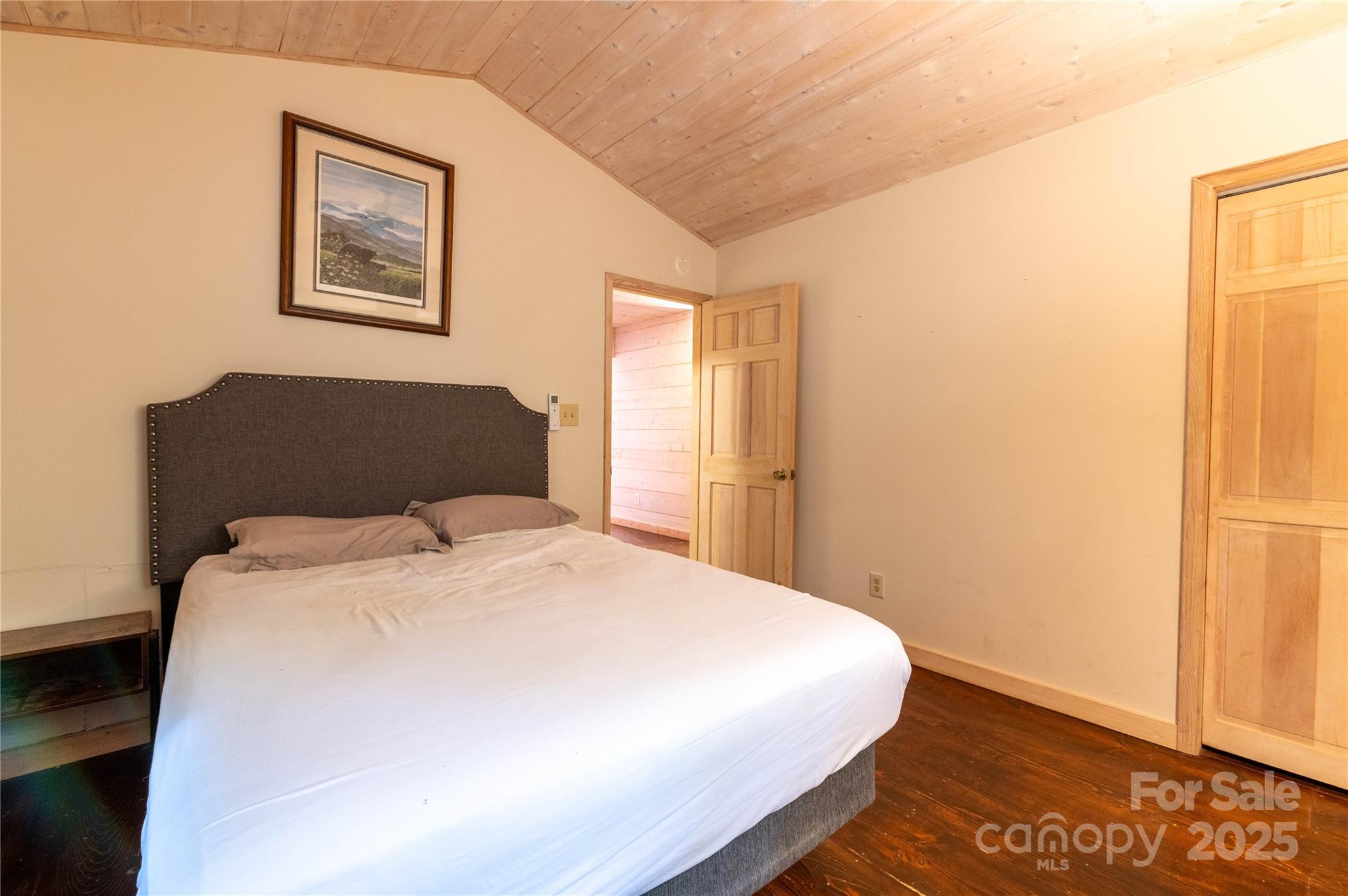 479 Big Ridge Road Burnsville, NC 28714 - Photo 14 of 40 a bedroom with a bed and a wall painting