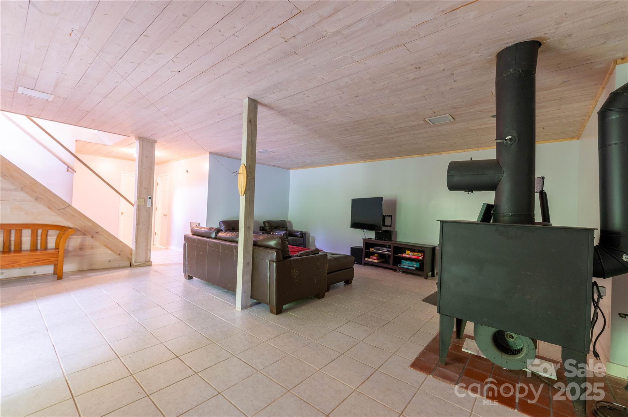 479 Big Ridge Road Burnsville, NC 28714 - Photo 26 of 40 a living room with furniture a flat screen tv and a floor to ceiling window