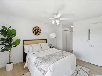 a bedroom with a large bed and a potted plant