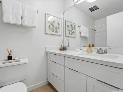 a bathroom with a sink a toilet and mirror