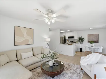 a living room with furniture and a view of kitchen
