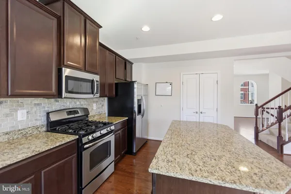a kitchen with stainless steel appliances granite countertop a stove refrigerator and microwave