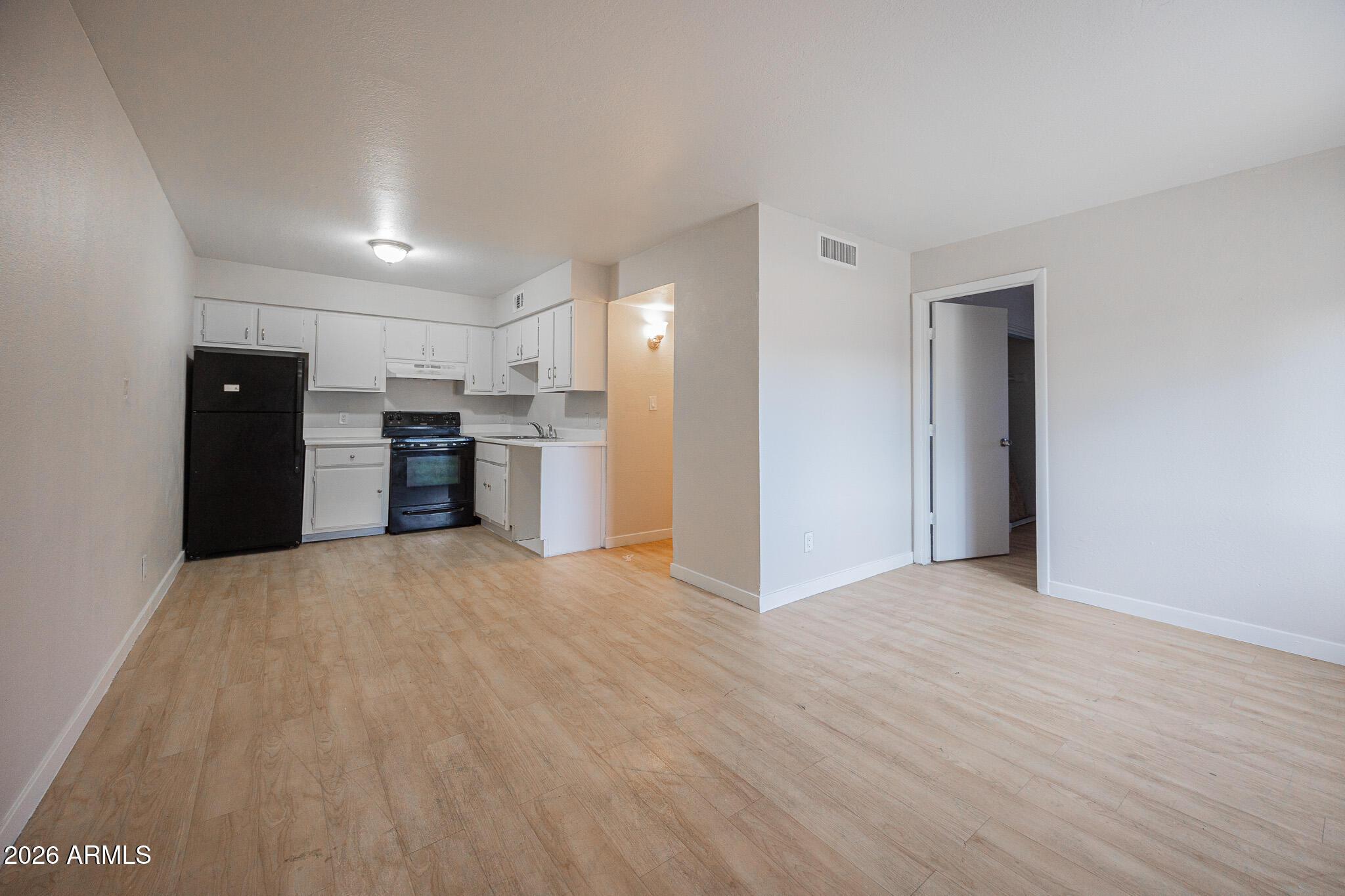 1703 West Mountain View Road, Unit 4 Phoenix, AZ 85021 - Photo 3 of 13 a view of a kitchen with a stove cabinets and wooden floor