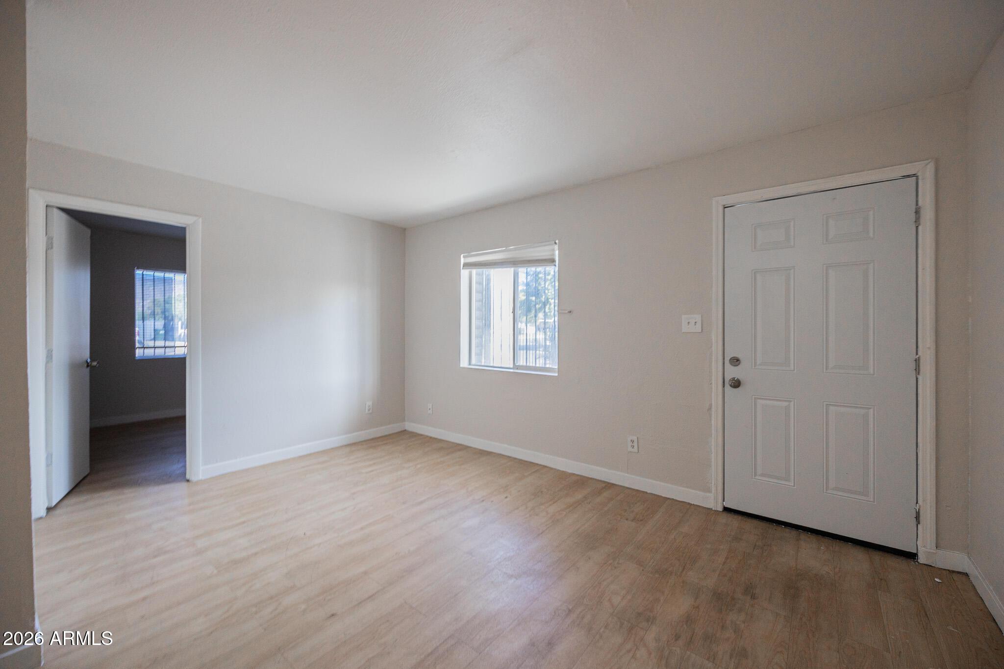 1703 West Mountain View Road, Unit 4 Phoenix, AZ 85021 - Photo 4 of 13 a view of an empty room with wooden floor and closet