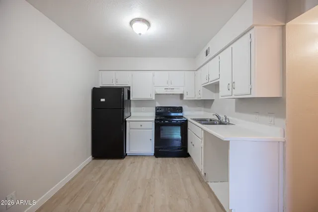 a kitchen with a refrigerator and a stove top oven