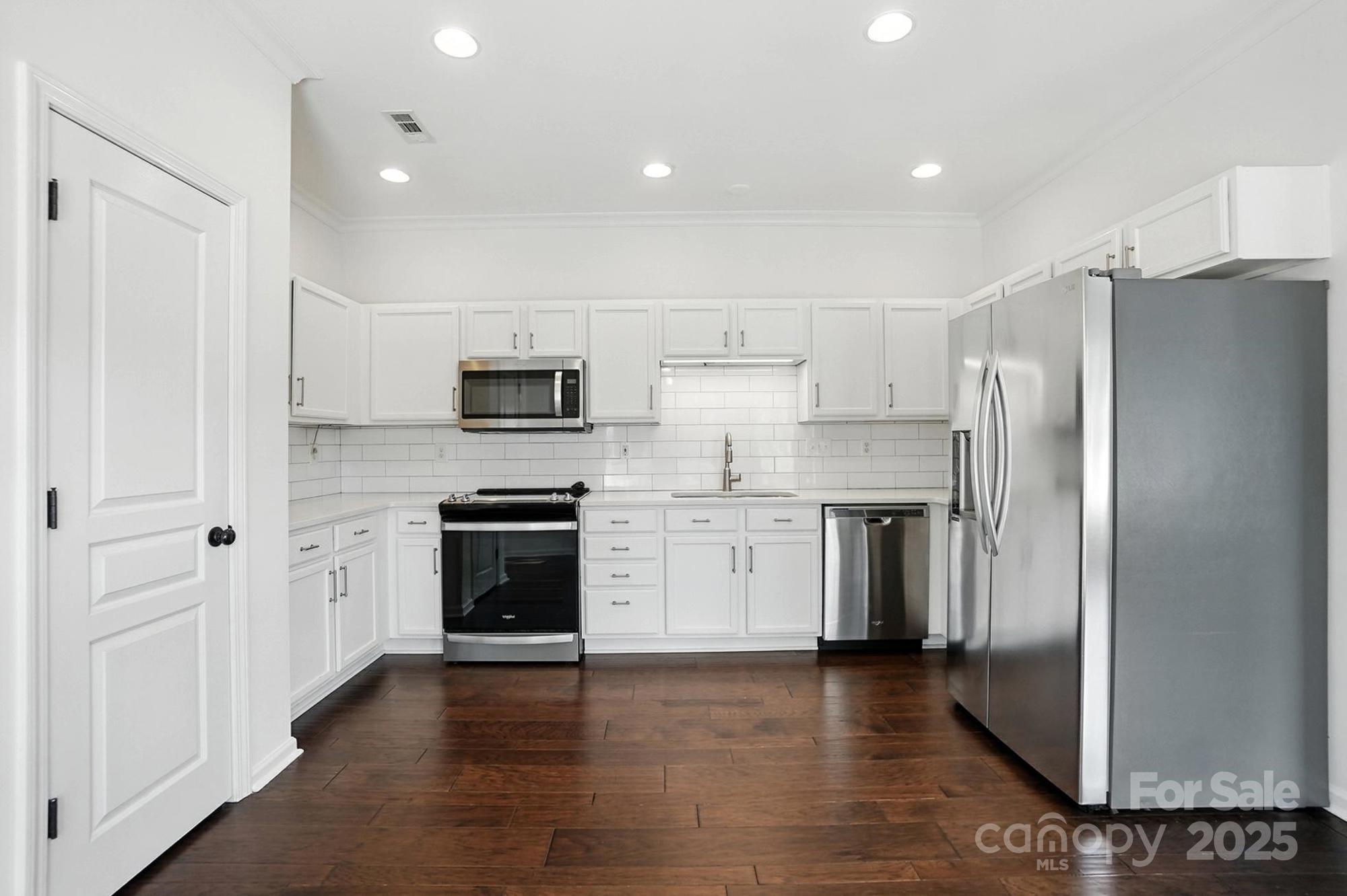 8710 Arrowhead Pl Lane Cornelius, NC 28031 - Photo 31 of 48 a kitchen with a refrigerator stove and wooden cabinets