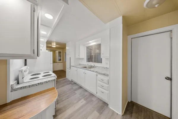 a large white kitchen with cabinets