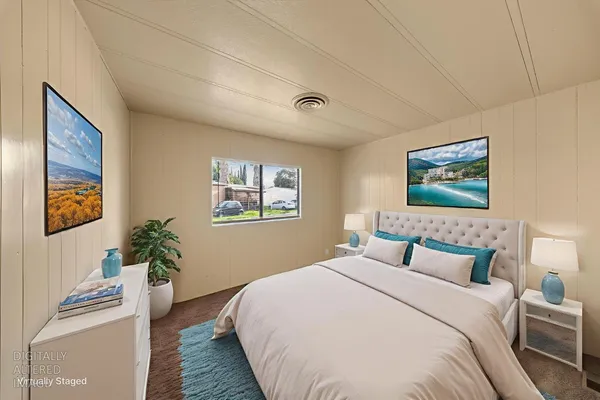 a bedroom with a bed and a painting on the wall