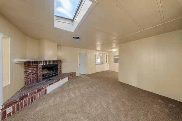 a view of an empty room with a fireplace and a window